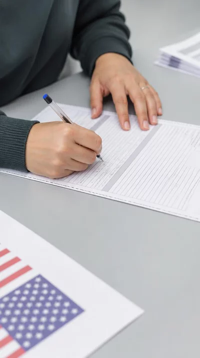 Person filling out official election paperwork, close-up of hands and forms